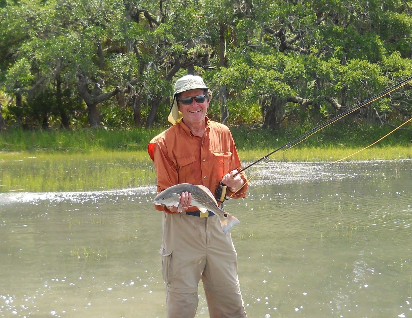 A man holding a fish and a rod on Hilton Head Island